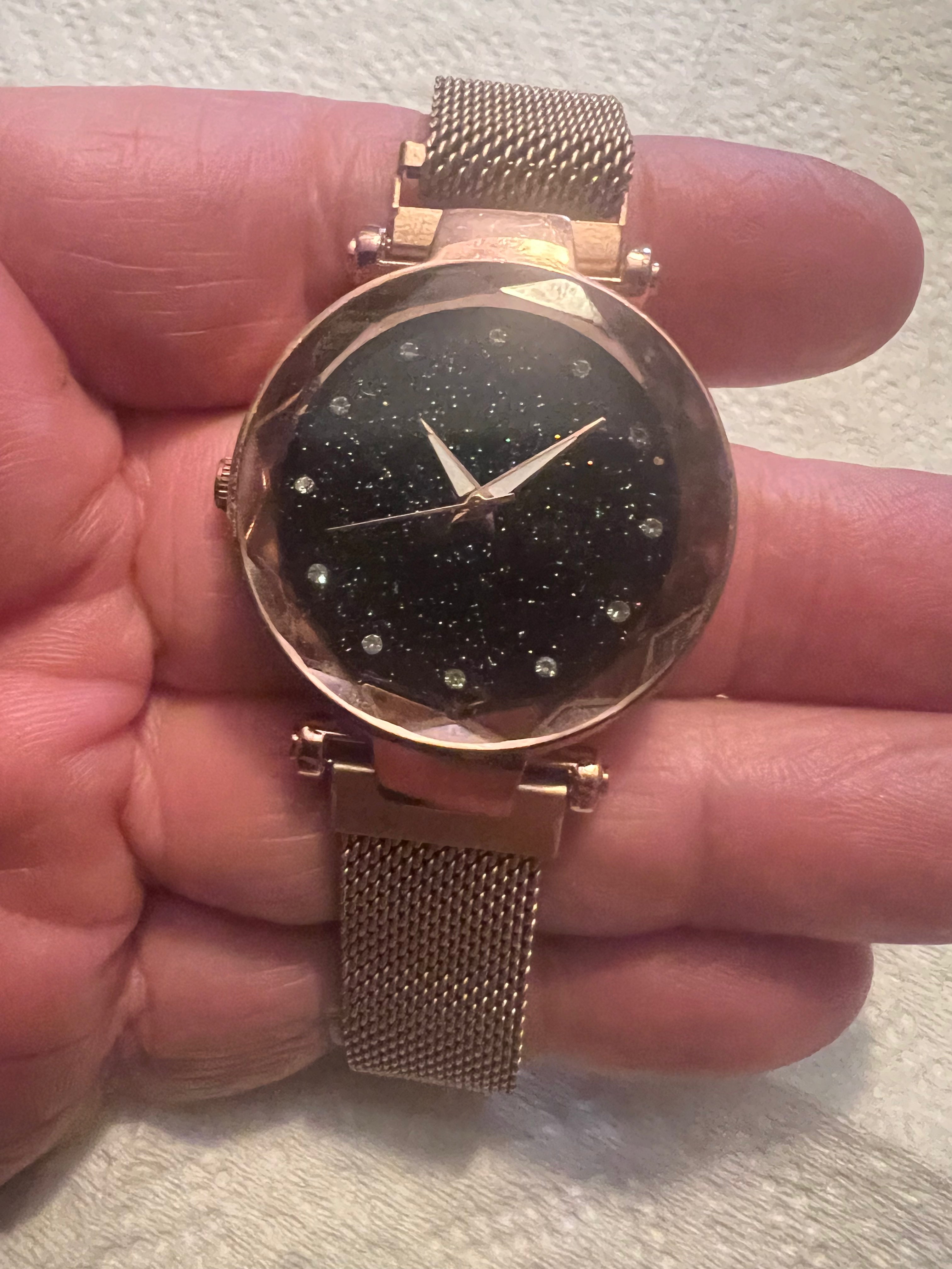 women's rose gold-toned quartz watch featuring a black "starry sky" glitter dial and a magnetic mesh strap.