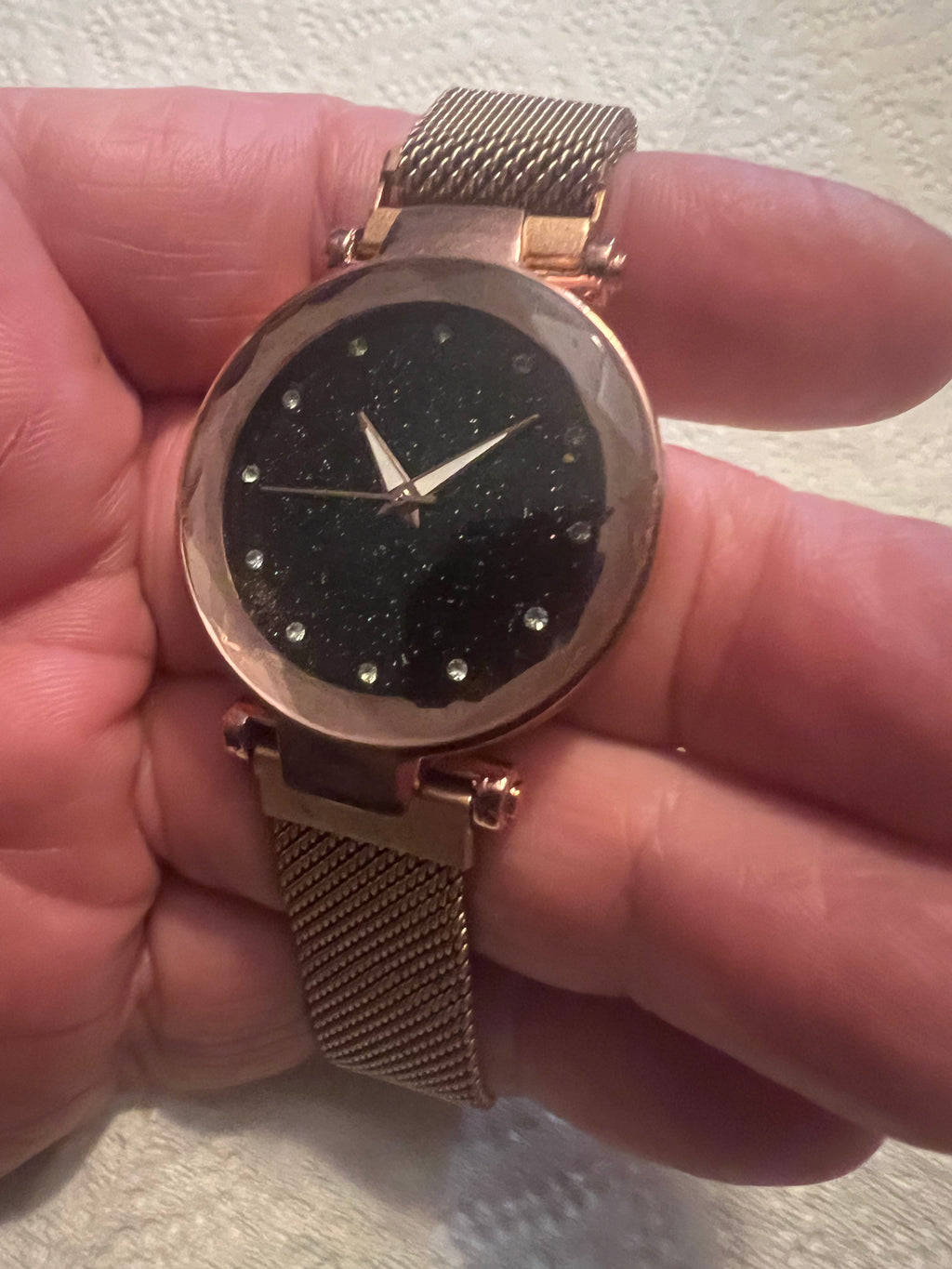 women's rose gold-toned quartz watch featuring a black "starry sky" glitter dial and a magnetic mesh strap.