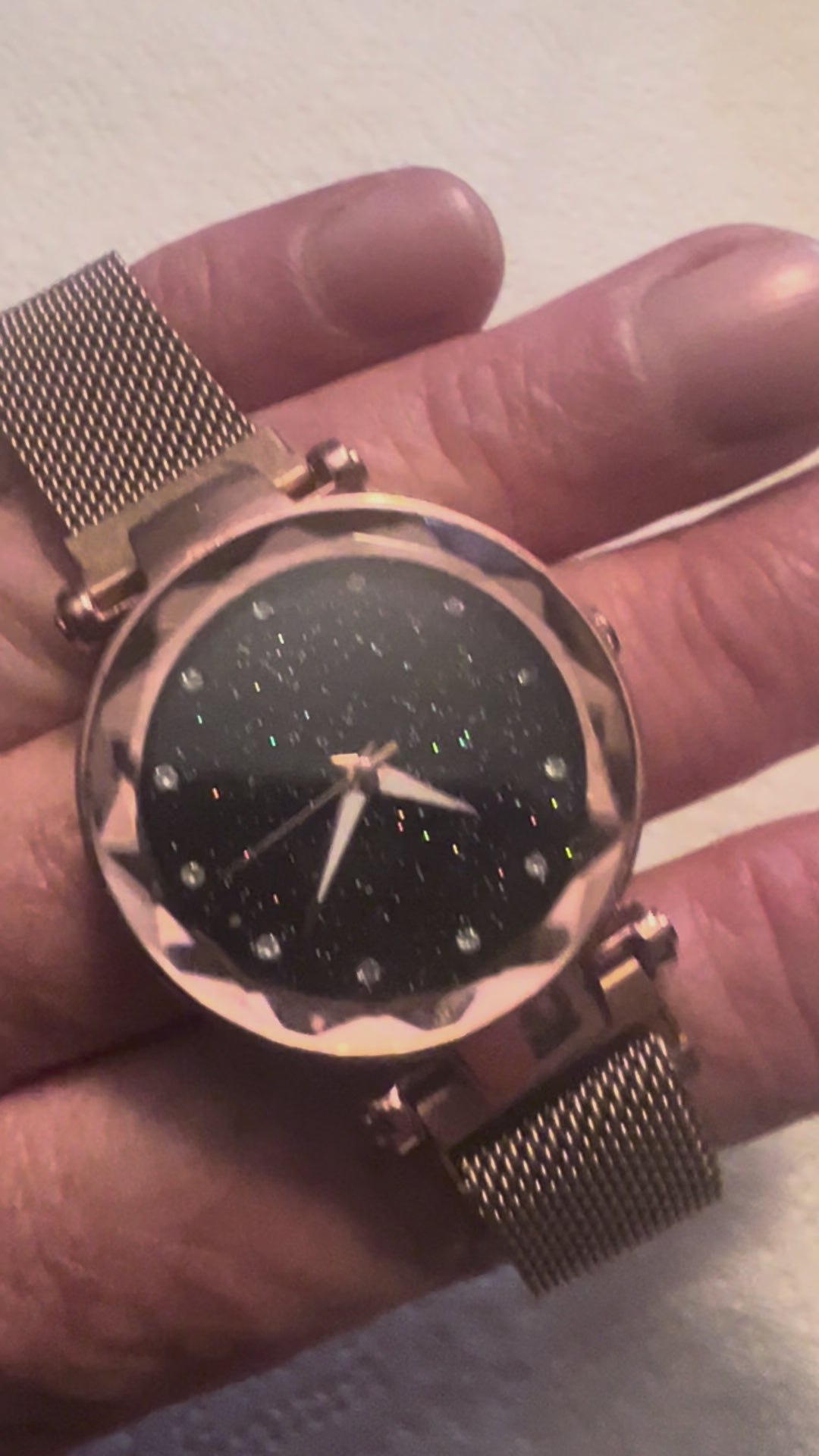 women's rose gold-toned quartz watch featuring a black "starry sky" glitter dial and a magnetic mesh strap.